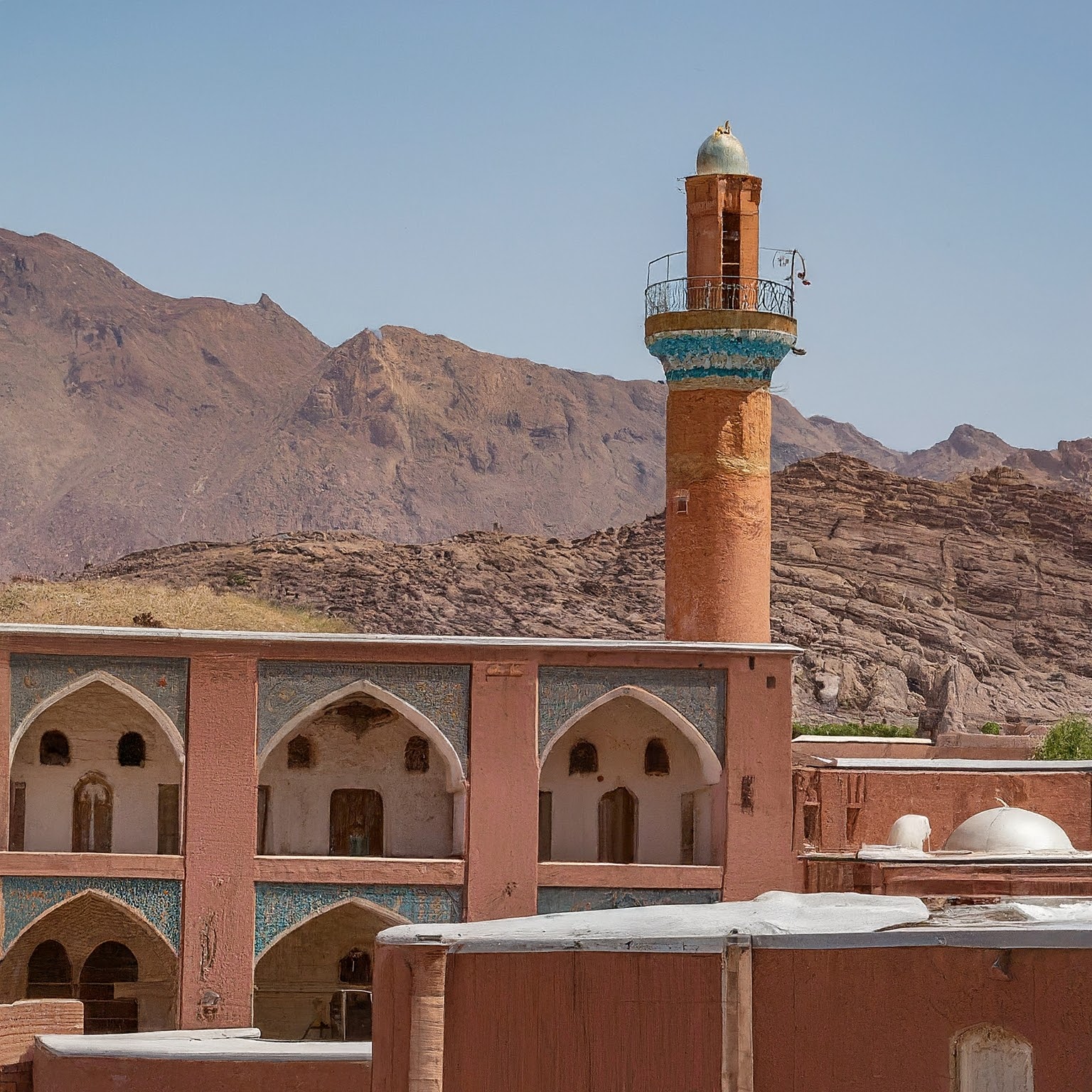 The historic Jameh Mosque of Abyaneh, Iran, with intricate brickwork and a towering minaret.
