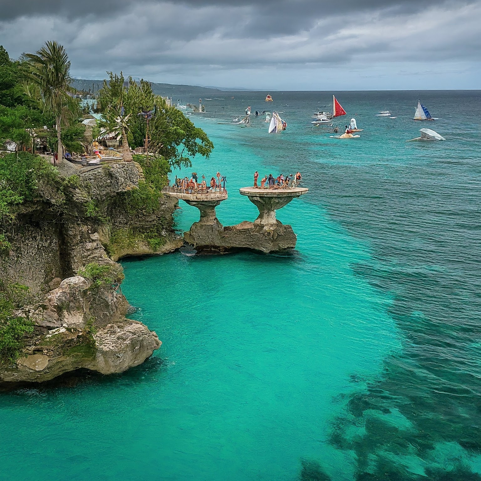 Boracay Island, Philippines: Cliff diving platform at Ariel's Point with divers and turquoise water.