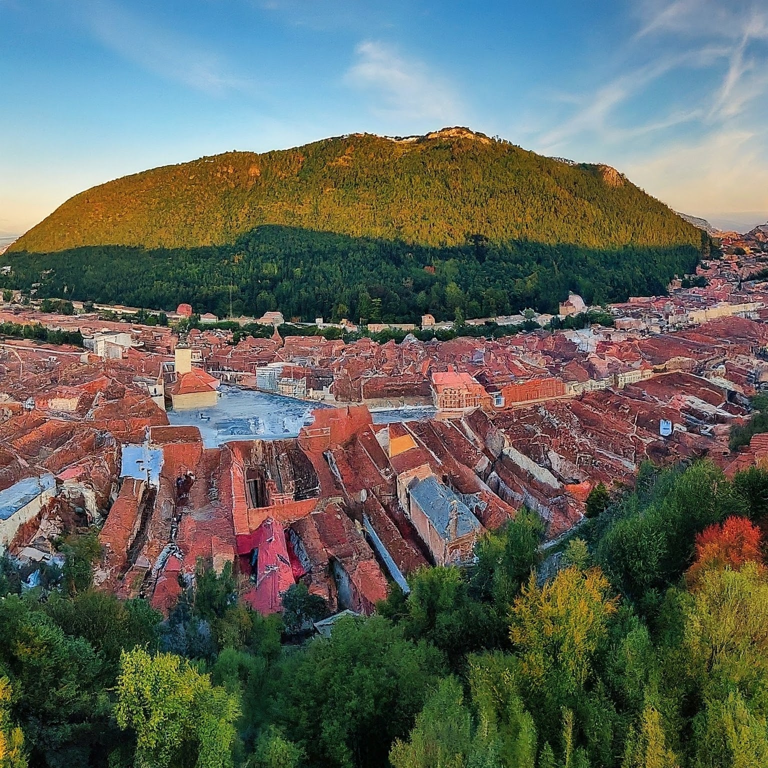 Panoramic view of Brasov, Romania, with colorful houses and Tâmpa mountain.