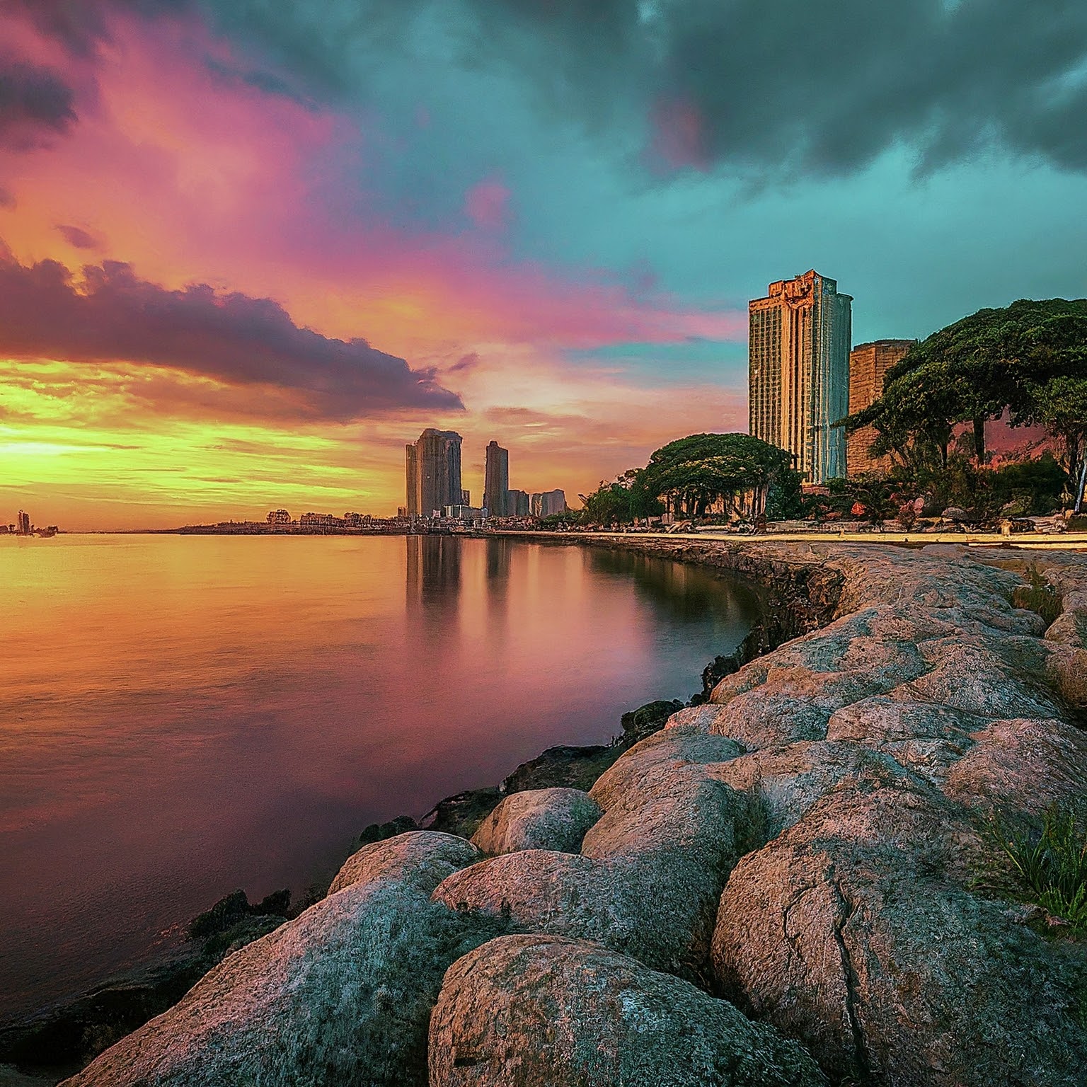 Manila Bay at sunset with colorful sky, Roxas Boulevard, and Cultural Center of the Philippines.